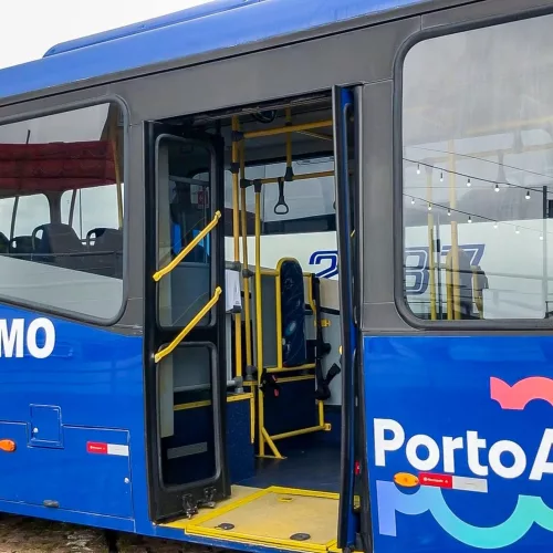 Ônibus da Linha Turismo, de Porto Alegre. O veículo é azul escuro e está com a porta central aberta.