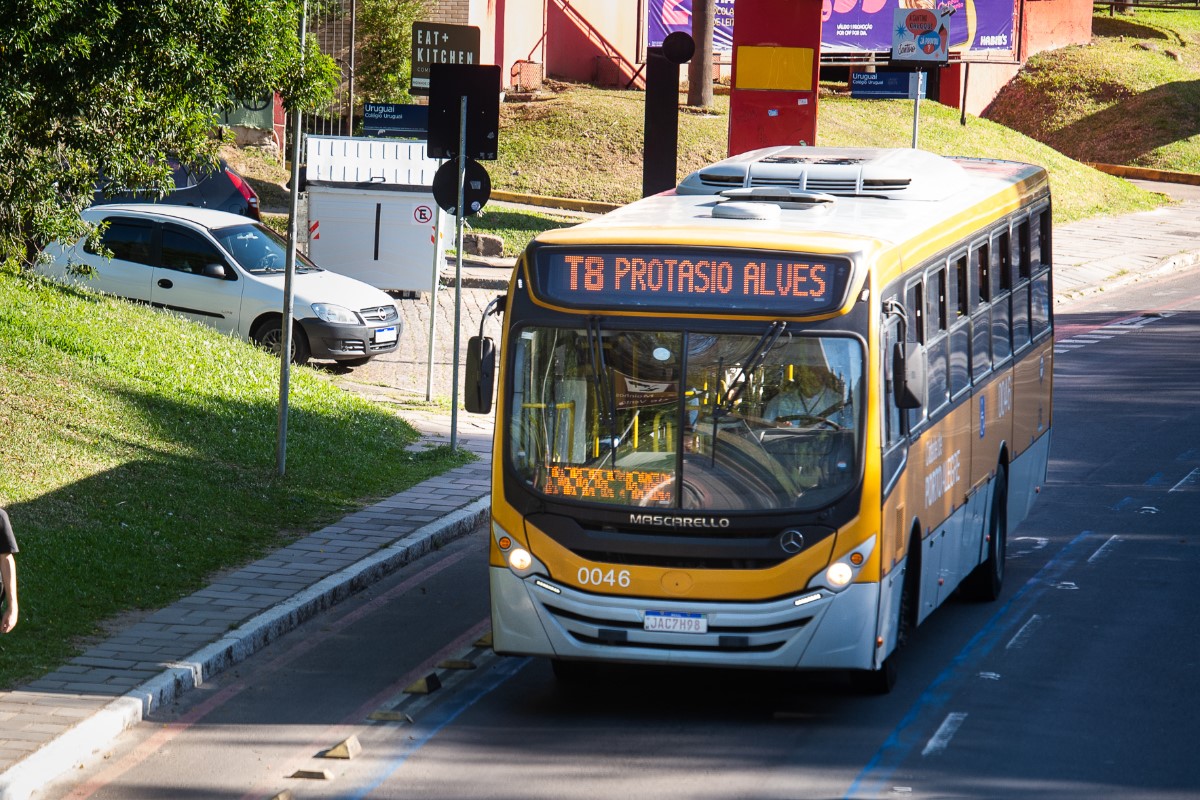Ônibus amarelo ocre, da Carris, passa pela avenida Goethe, em Porto Alegre. O letreiro aponta a linha T8 - Protásio Alves.