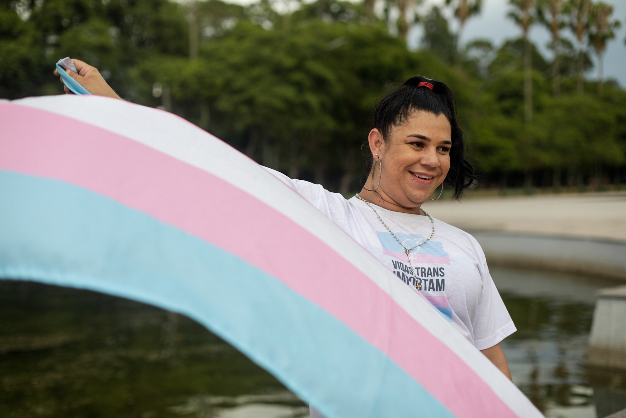 Transexual com a bandeira azul claro, rosa e branca que identifica este grupo de pessoas