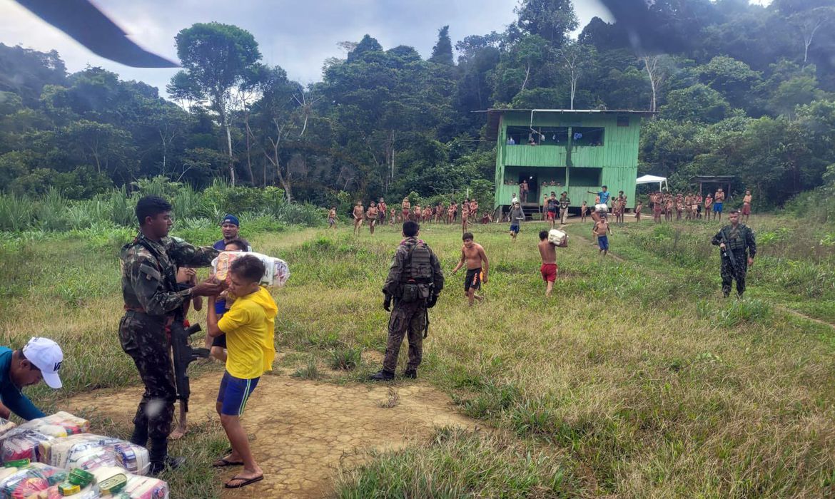 Militares com farda verde entregam cestas básicas para comunidades Yanomami